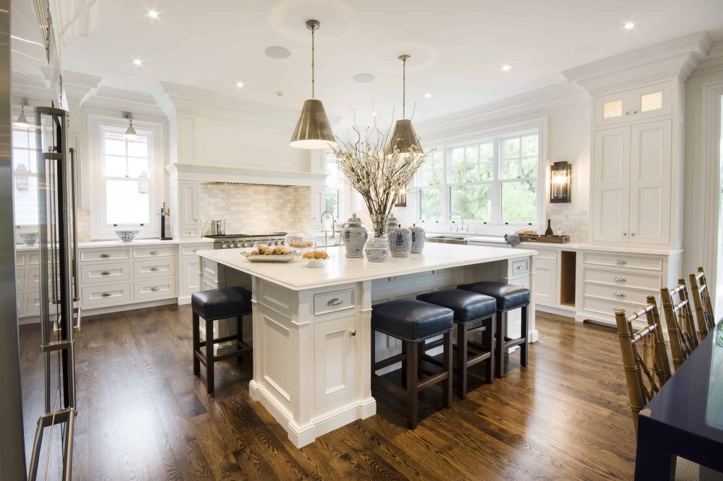 this image shows a fancy kitchen depicting a large centralized multi-purpose kitchen island